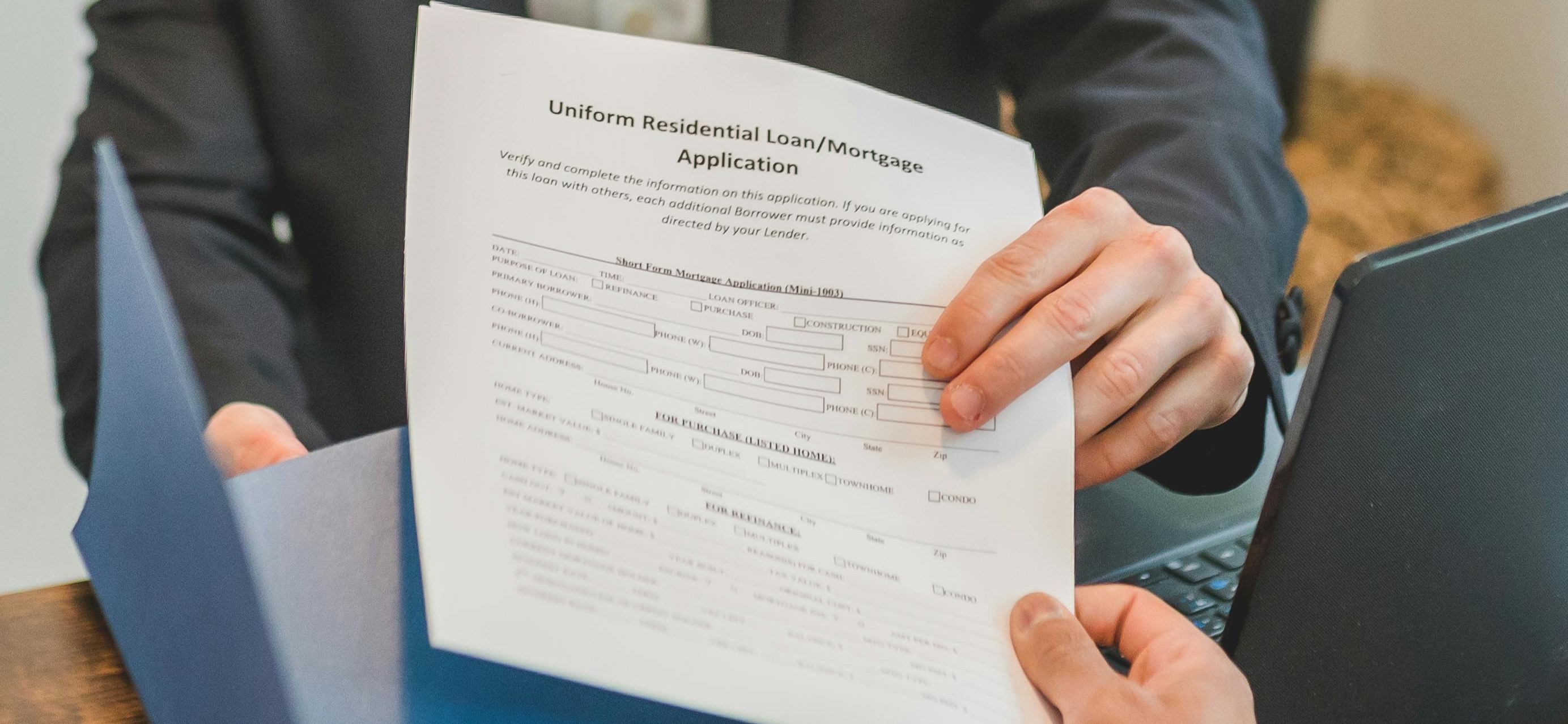 Person handing over a mortgage application document