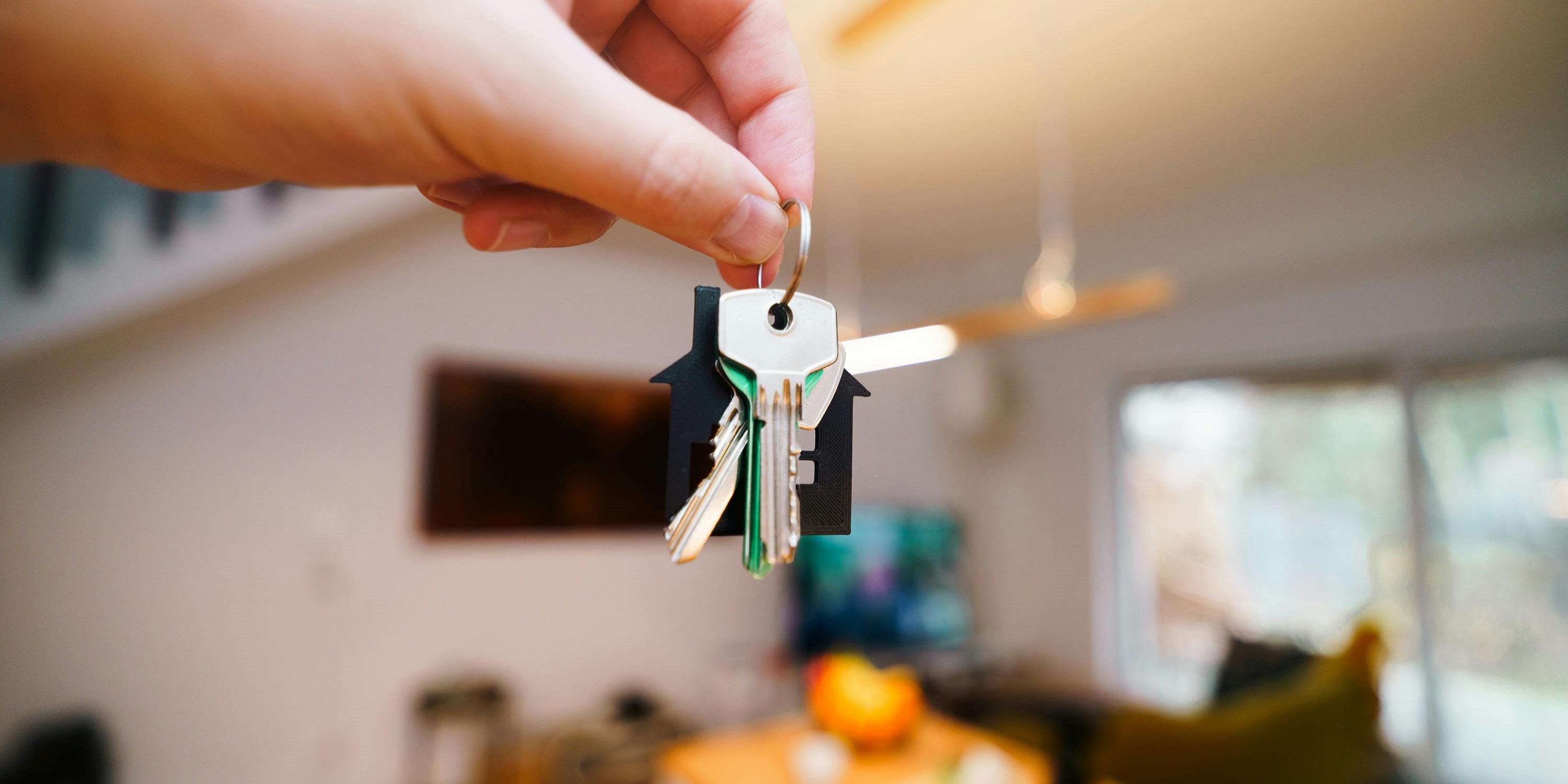 Hand Holding Keys in Modern Home Interior