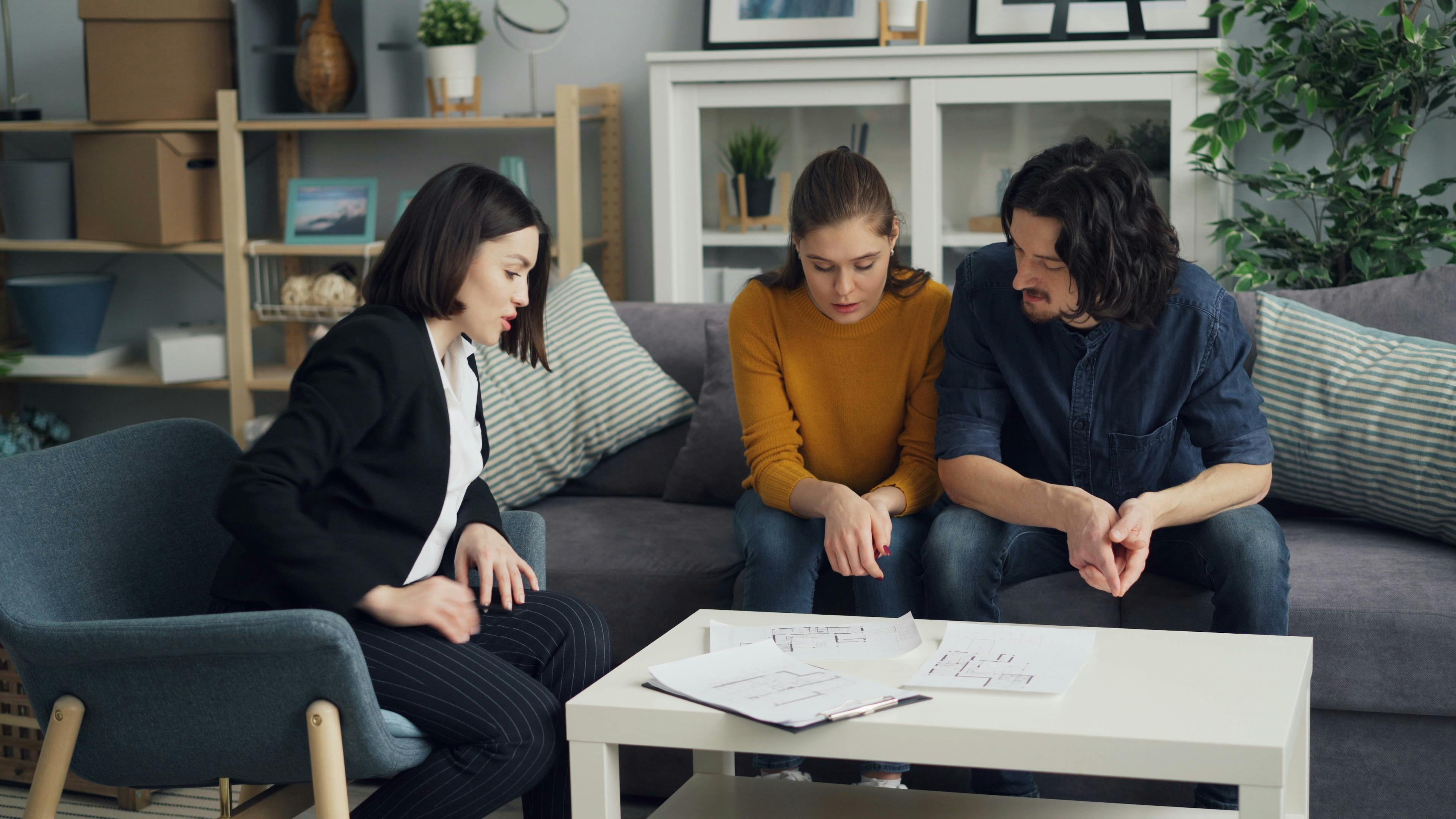 Real Estate Agent and Couple Sitting at Table