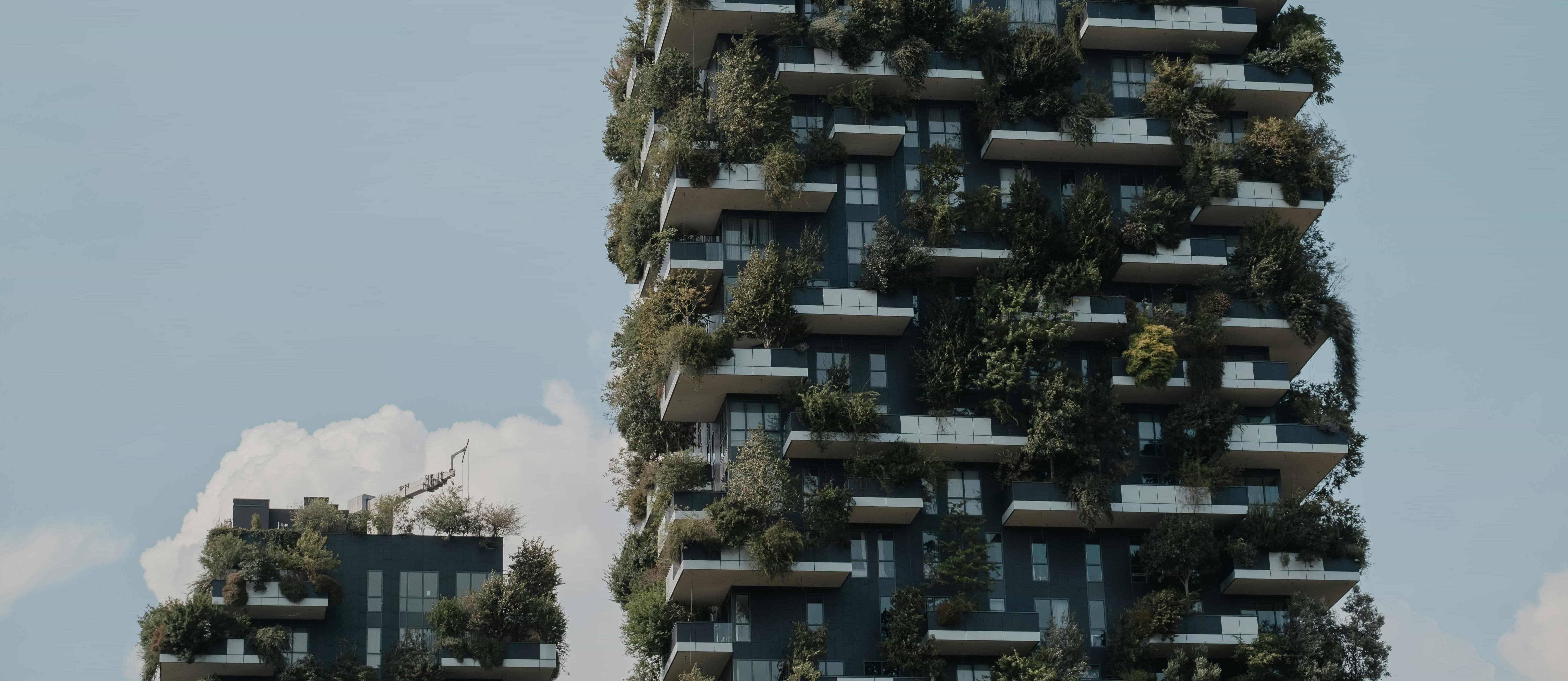 Two tall buildings with plants growing on them