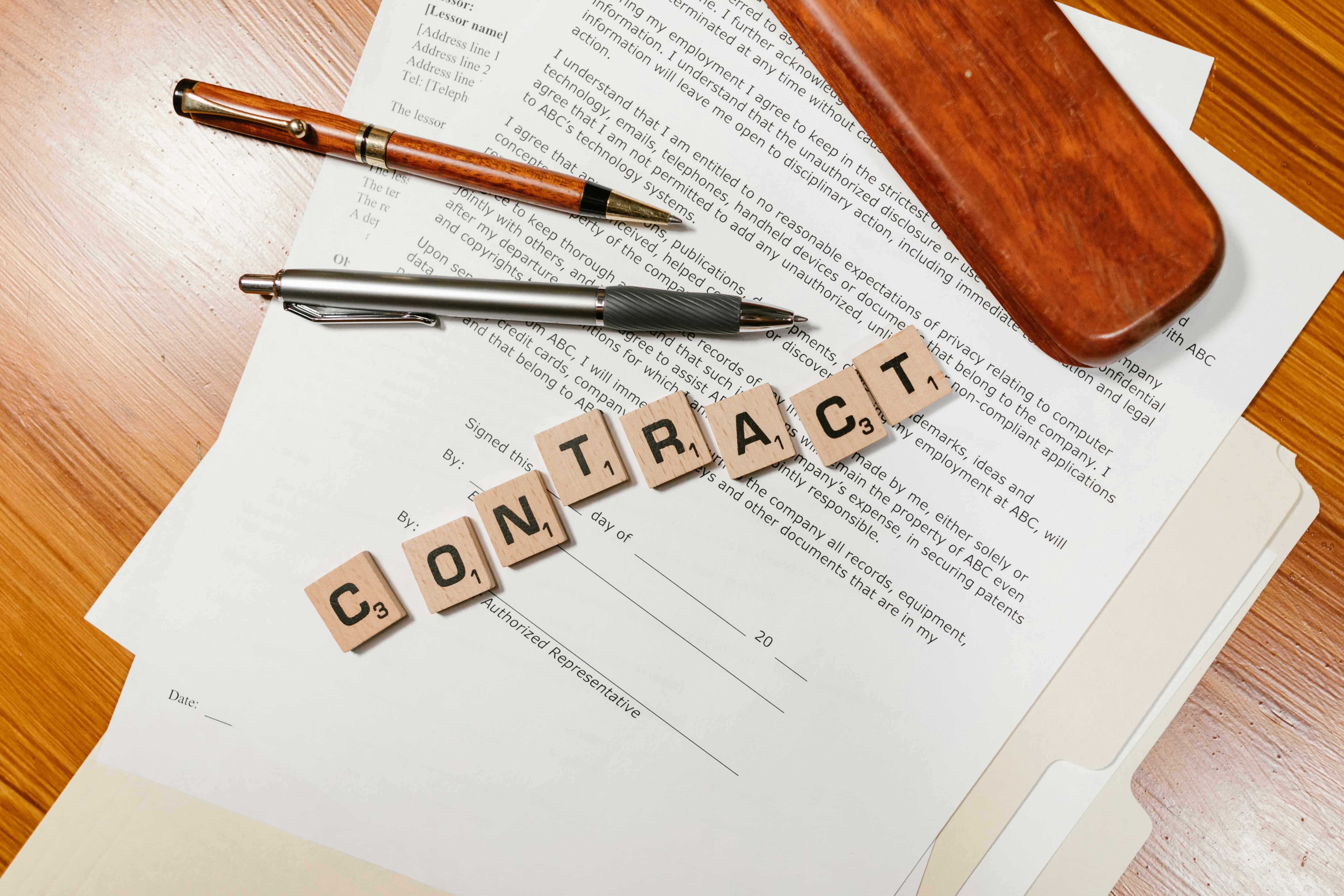 Contract Document with Letter Tiles and Pens