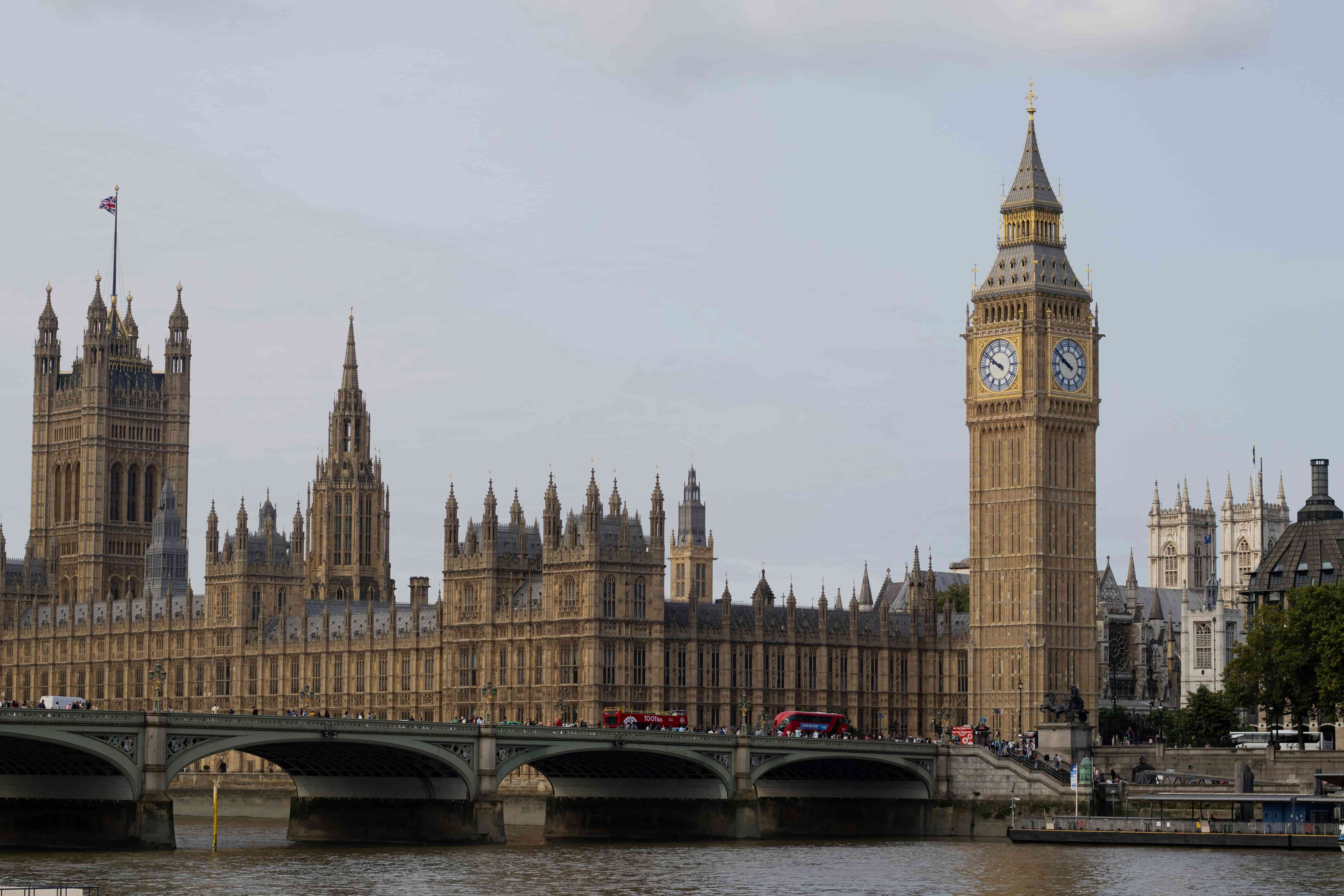 A large clock tower and a bridge over a river