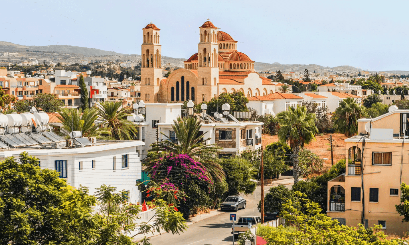 A whitewashed church with a red roof dominates the skyline of a traditional Paphos