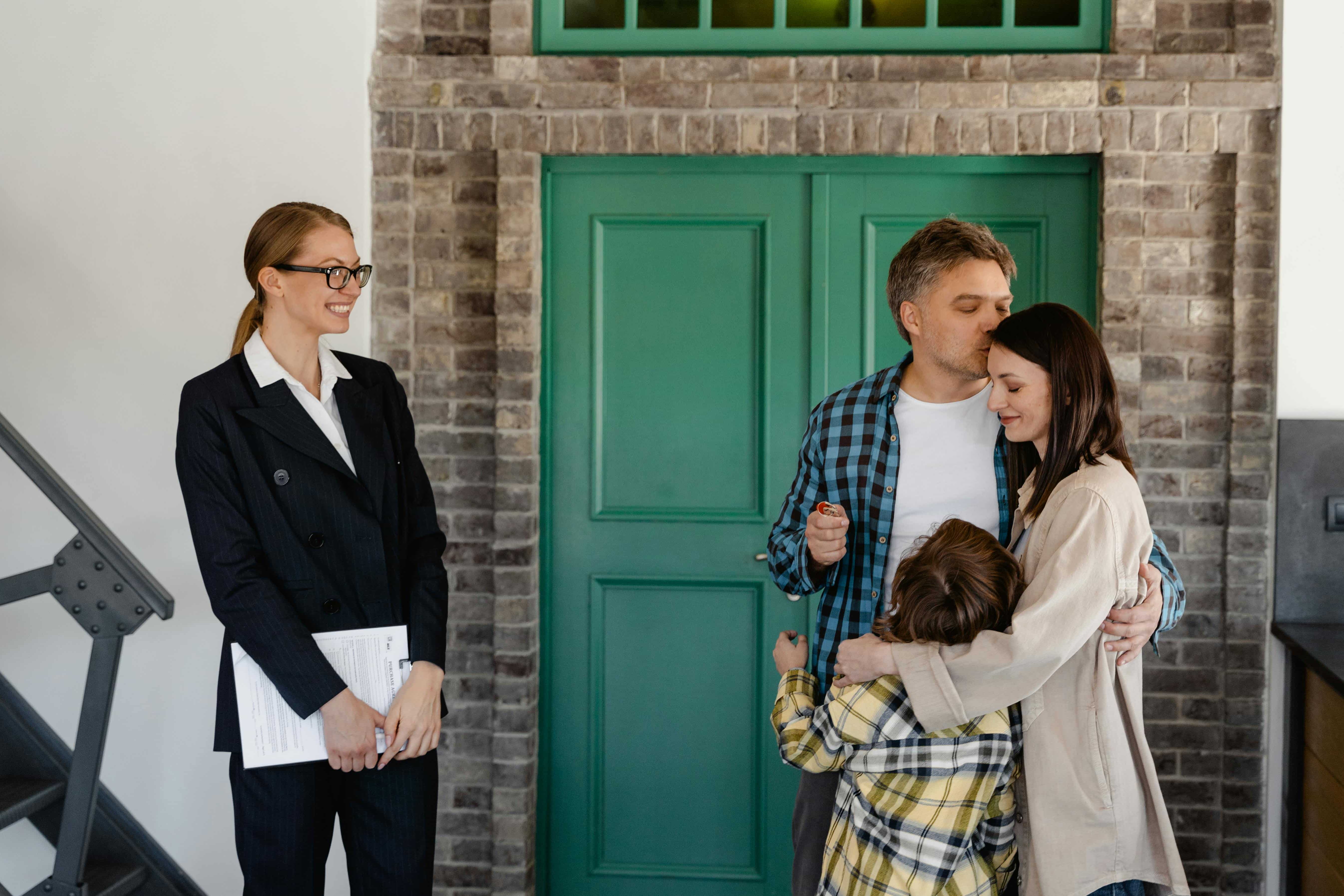 A real estate agent shows a family a house 